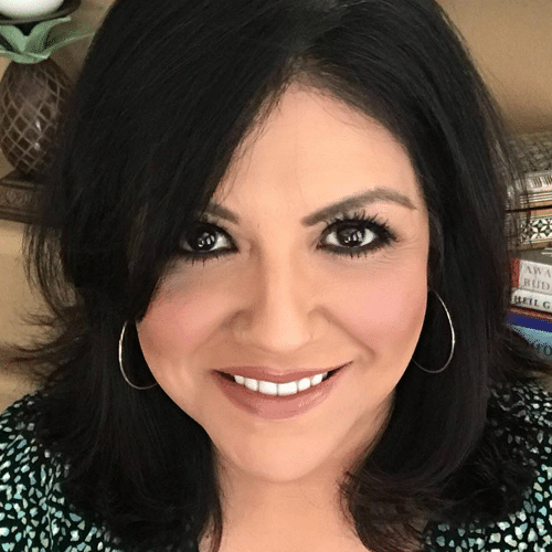Image of Gina Gomez in front of her book shelf